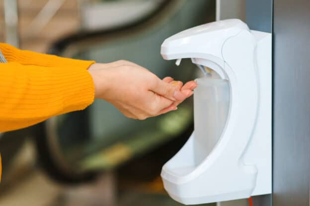 Woman using antiseptic gel. Coronavirus epidemic. Disinfection for hands in a shopping mall. Female applying a disinfectant for hands, close up. Coronavirus outbreak.